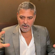George Clooney mid-sentence, holding hands out in front of him